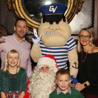 Louie and Santa posing with alumni family of four